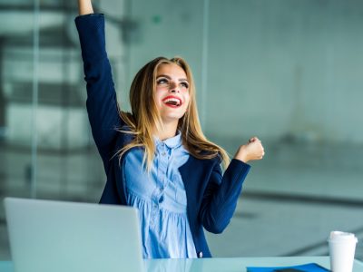 successful-young-business-woman-with-arms-up-at-the-office_CARRE_720x720