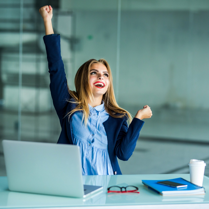 successful-young-business-woman-with-arms-up-at-the-office_CARRE_720x720