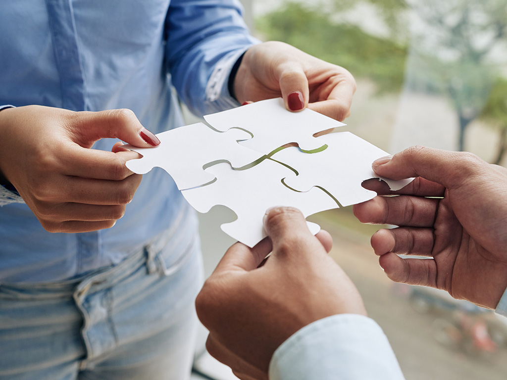 Close-up image of business people assembling puzzle